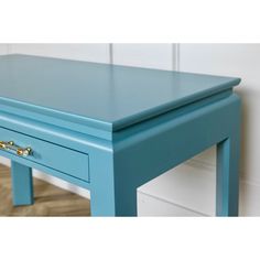 a small blue table with two drawers on each side and one drawer at the top