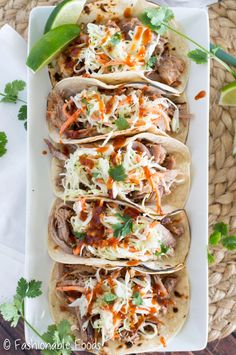 several tacos are lined up on a white plate