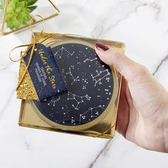 a woman's hand is holding a gift box with a star sign on it