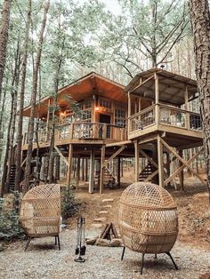 two wicker chairs sitting in front of a tree house