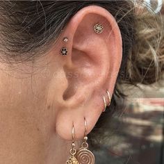 a woman's ear with three different earrings on it