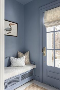 a blue room with a bench and window