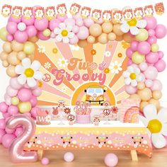 a pink and yellow birthday party with balloons, decorations and table cloths on the floor