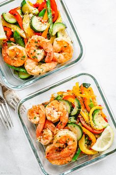 two glass dishes filled with shrimp and veggies on top of a white table