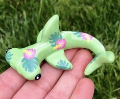 a hand holding a small green toy fish