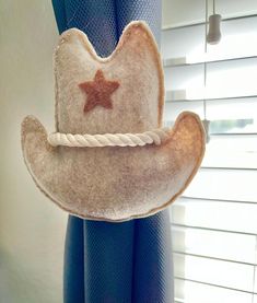 a cowboy hat hanging from the side of a window sill with a star on it