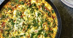 an omelet with cheese and spinach in a pan next to a plate