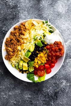 a white plate topped with lots of different types of food on top of a table