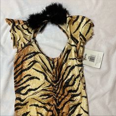 an animal print dress with a fur collar on it's neck and two small tags attached to the back