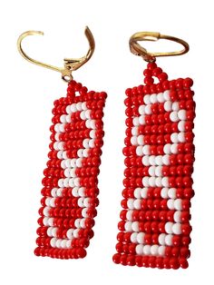 two red and white beaded earrings hanging from hooks