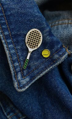 a tennis racket and ball are in the pocket of a pair of blue jeans