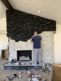 a man standing in front of a fireplace that has been built into the side of it