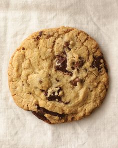 a chocolate chip cookie sitting on top of a white cloth