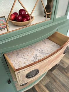 a bowl of apples sitting on top of a cabinet