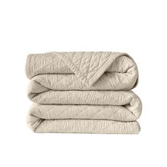 two blankets folded on top of each other in beige color, with one blanket folded over the