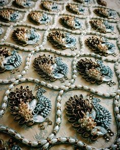 a table topped with lots of beads and brooches on top of a cloth