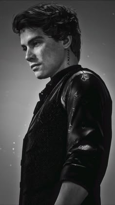 black and white photograph of a young man in leather jacket looking at the camera with serious expression on his face