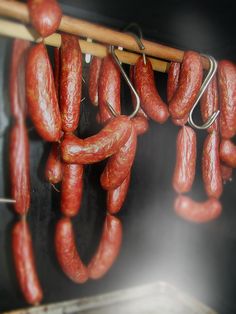 several sausages hanging from a wooden rack