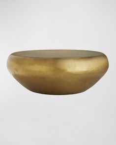 a gold bowl hanging from the ceiling in front of a white wall with a grey background