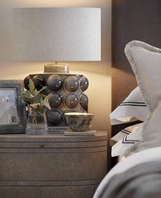 a nightstand with a lamp and pictures on it