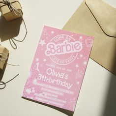 a pink birthday card sitting on top of a table next to some brown envelopes