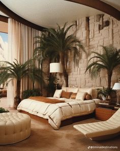 a large bed sitting next to a window in a living room filled with furniture and palm trees