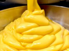 a large metal bowl filled with yellow liquid