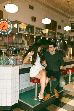 a man and woman sitting at a bar