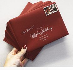 a person holding red envelopes on top of each other with two photos attached to them