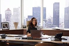 a woman sitting at a desk in front of a laptop computer