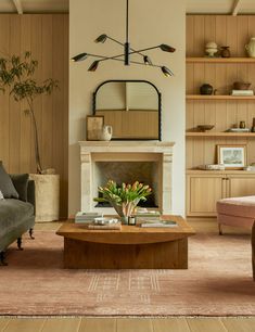 a living room filled with furniture and a fire place in front of a fireplace surrounded by wooden shelves