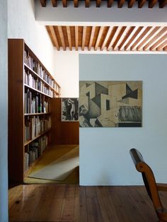 a chair sitting in front of a book shelf filled with books