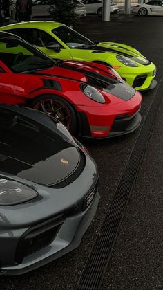 there are many different colored cars parked in the parking lot, all lined up together