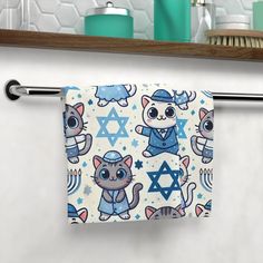 a towel hanging on a bar in a bathroom with cats and jewish symbols all over it