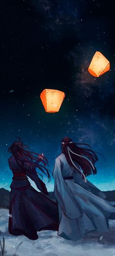 two people standing in the snow with lanterns flying above their heads and one person looking up at the sky