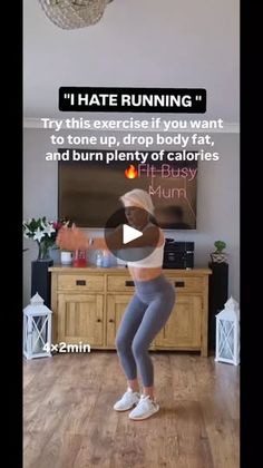 a woman in grey pants and white top doing a dance move on a wooden floor