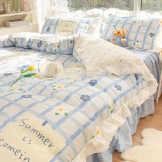 a bed with blue and white checkered comforter, teddy bear pillowcases and pillows