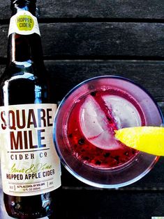 a bottle of soda next to a glass filled with liquid