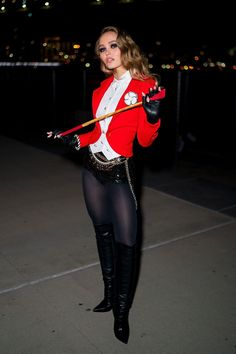 a woman dressed in costume is holding a bat and posing for a photo on instagram