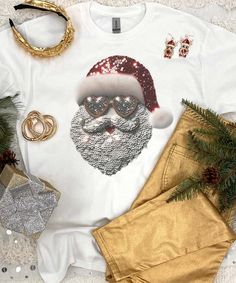 Introducing our Faux Sequin Santa Graphic Shirt, the perfect addition to your festive wardrobe this holiday season. This eye-catching shirt features a stunning faux sequin Santa face design that is sure to make you the life of the Christmas party. The beauty of this shirt lies in its clever use of faux sequins(these are not real sequins, they are grapic sequins). Our faux sequin design is not shiny/sparkly. This is a printed graphic design that is meant to give the look of sequins, it is not real sequins. It does look exactly like the photo as this is a printed graphic tee that shows the actual design printed on the tee.
Our Christmas shirt boasts a jolly Santa Claus graphic that captures the spirit of the season, making it an ideal choice for spreading joy and merriment. Whether you're lo Santa Graphic, Santa Shirt, Holiday Attire, Black Friday Christmas, Beach Birthday, Jolly Santa, Santa Shirts, Santa Face, Office Parties