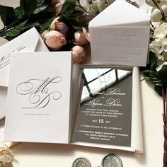 the wedding stationery is laid out next to some flowers