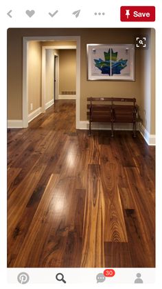 an empty hallway with wood floors and benches