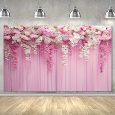 a wall with pink curtains and white flowers on the curtain is in an empty room