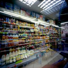 a grocery store filled with lots of different types of drinks and condiments on shelves