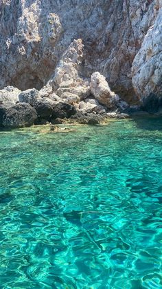 the water is crystal blue and clear with rocks in the backgroung area