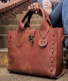 a woman sitting on the steps holding a brown purse