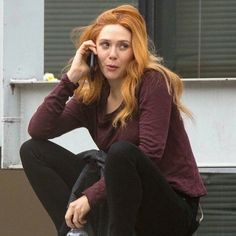 a woman sitting on the steps talking on her cell phone