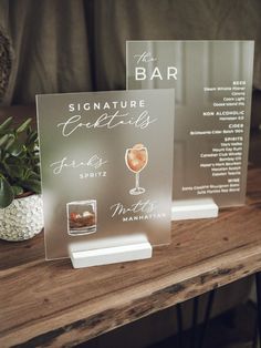 there are two signs on the table that say signature cocktails and drink menus