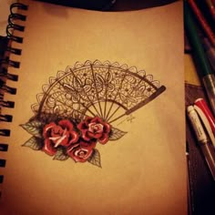 a drawing of an umbrella with roses on it next to colored pencils and markers