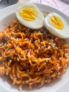 an egg sits on top of noodles in a white bowl